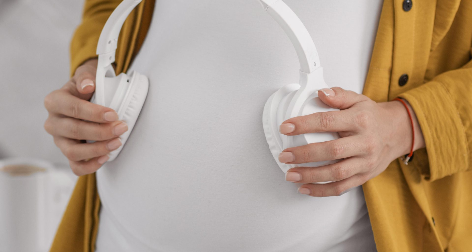 pregnant-woman-holding-headphones-her-belly
